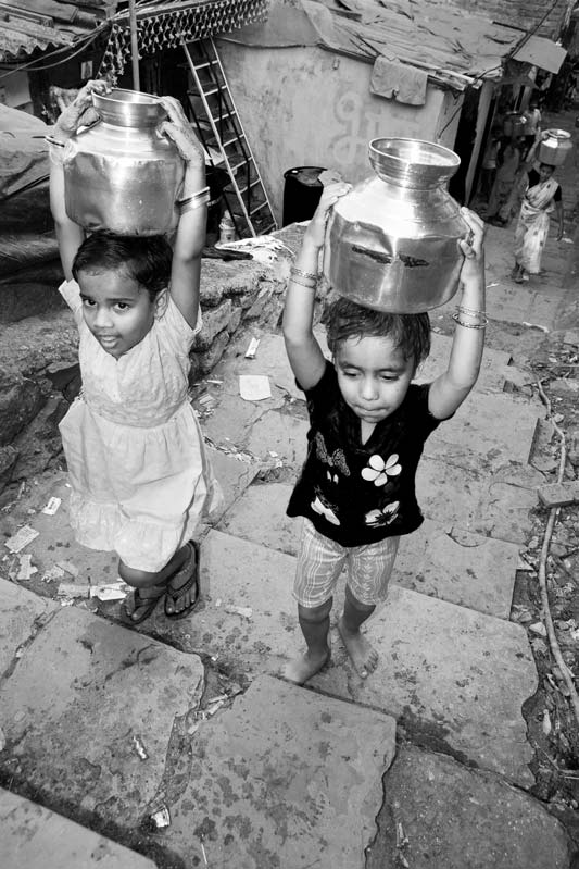 Children and Water - Very small children carrying loads of water uphill in Mumbai, Maharashtra